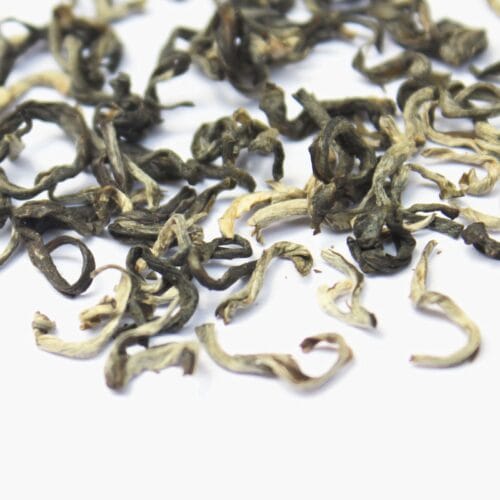 Cánh trà khô của lục trà shan tuyết cổ thụ màu xanh đen, có phủ lớp tuyết trắng.